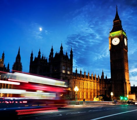 Red bus, Big Ben and Westminster Palace in London, the UK. at night. Moon shining